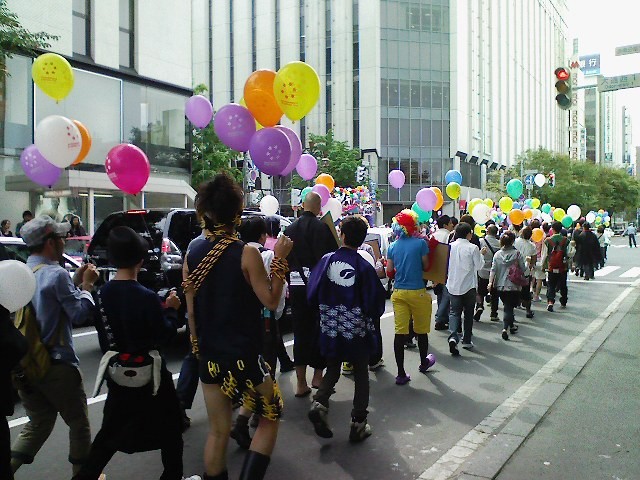 写真：虹色の風船を手に、繰り出す人々