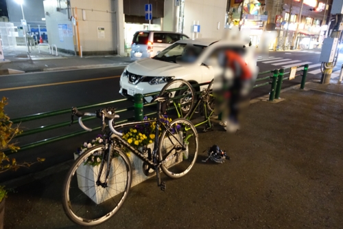 京成大久保駅前で輪行袋から自転車を出す